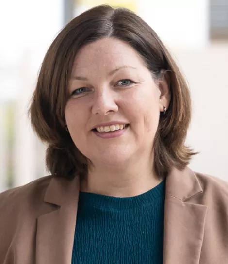 Professional portrait of Susanne Schmidt, managing director, smiling in business attire.
