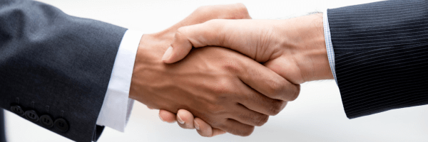 Close-up of a business handshake between two people in suits.