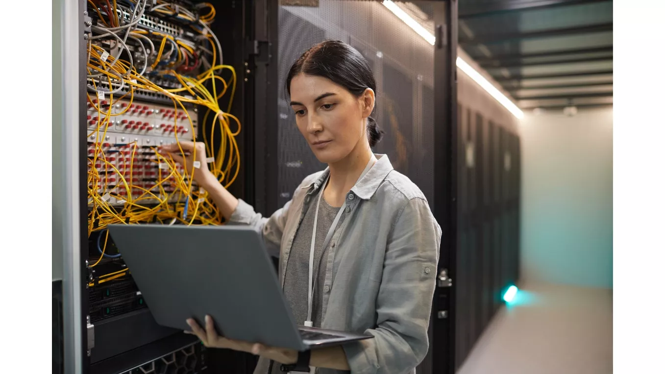 Person working on a laptop in front of a server