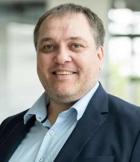 Professional portrait of Andreas Stroppel, managing director, smiling in business attire.